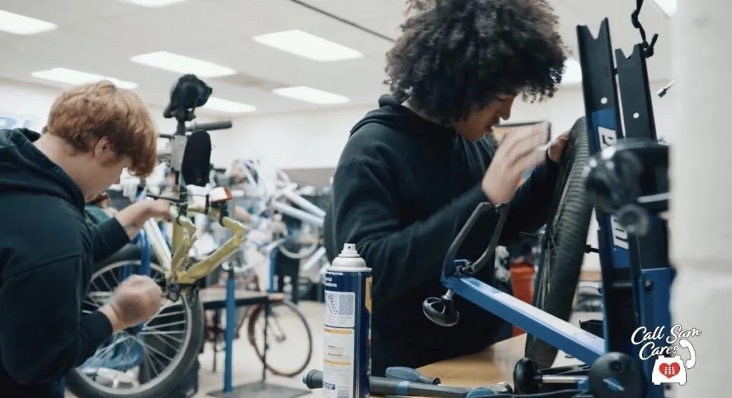 2 guys working on fixing bikes