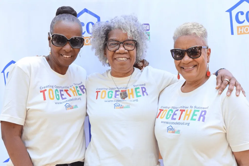 3 women standing with arms around each other